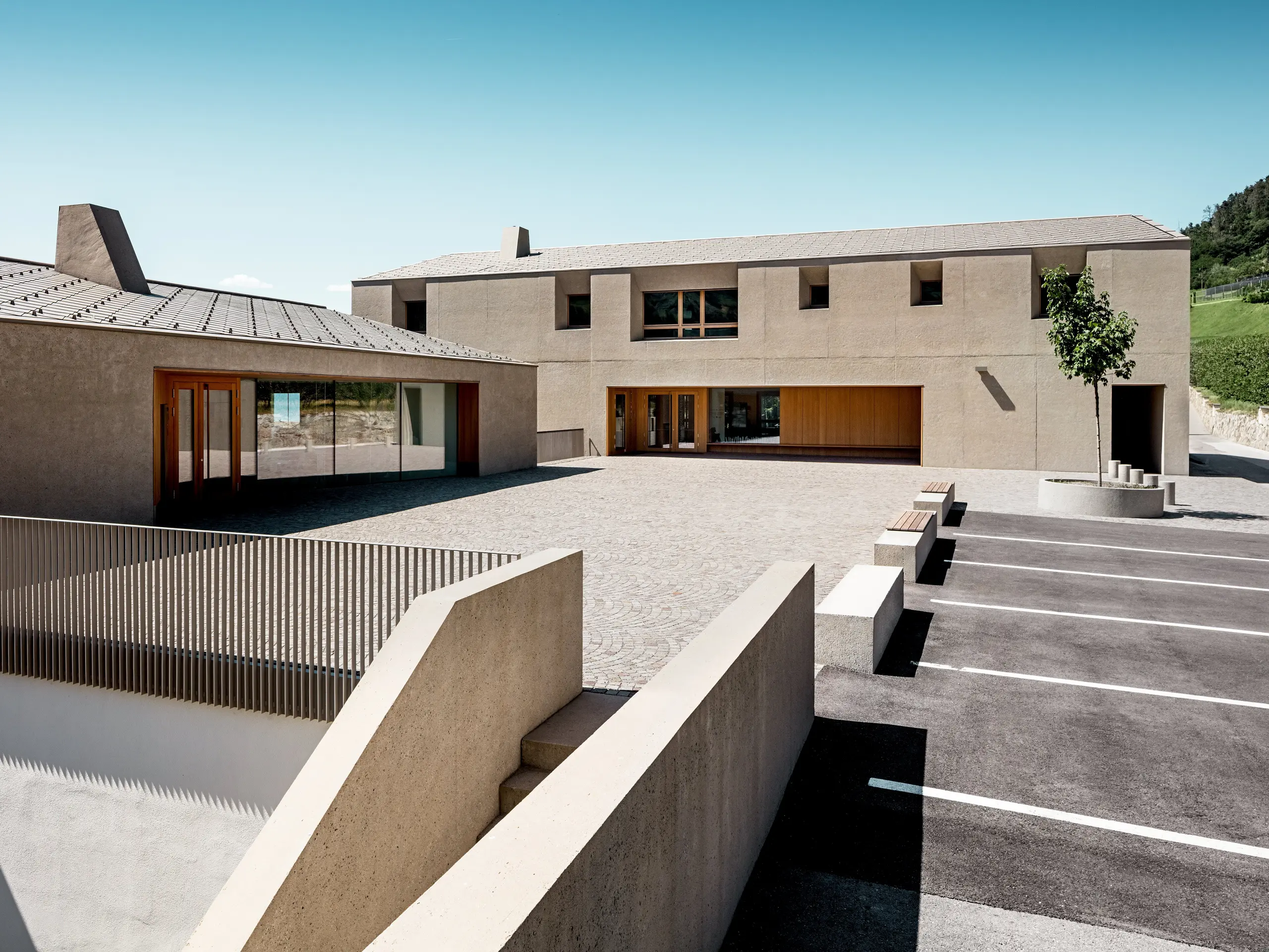 Vzdelávacie centrum Riffian v Južnom Tirolsku spája modernú architektúru s precízne navrhnutým riešením strechy. Dva stavebné objekty so strešnými šablónami PREFA 44 × 44 v odtieni P.10 bronzová harmonicky zapadajú do okolitej krajiny. Odolná hliníková strešná krytina poskytuje spoľahlivú ochranu pred poveternostnými vplyvmi a zároveň zvýrazňuje čistý architektonický výraz školského areálu.