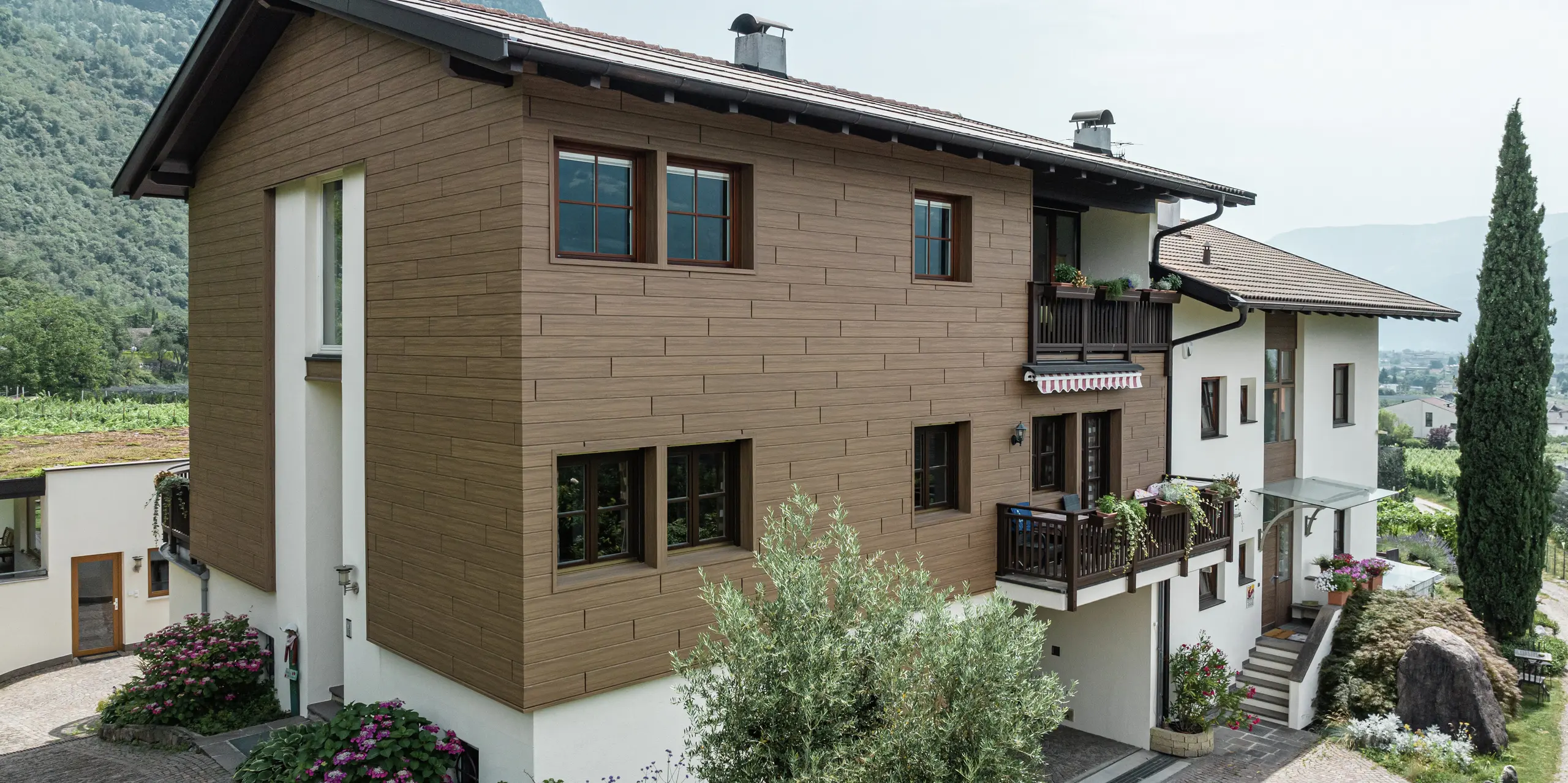 Modernizované rekreačné apartmány Prechtlhof v Merane v Južnom Tirolsku s odolnou fasádou PREFA v orechovo hnedom vyhotovení. Hliníkové obklady v drevenom vzhľade spájajú tradičnú estetiku s bezúdržbovou odolnosťou a harmonicky zapadajú do alpského prostredia.