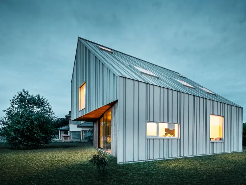 Samostatne stojaci dom dvojice architektov. Strecha a fasáda boli obložené plechmi Prefalz vo farbe P.10 Prefa biela.