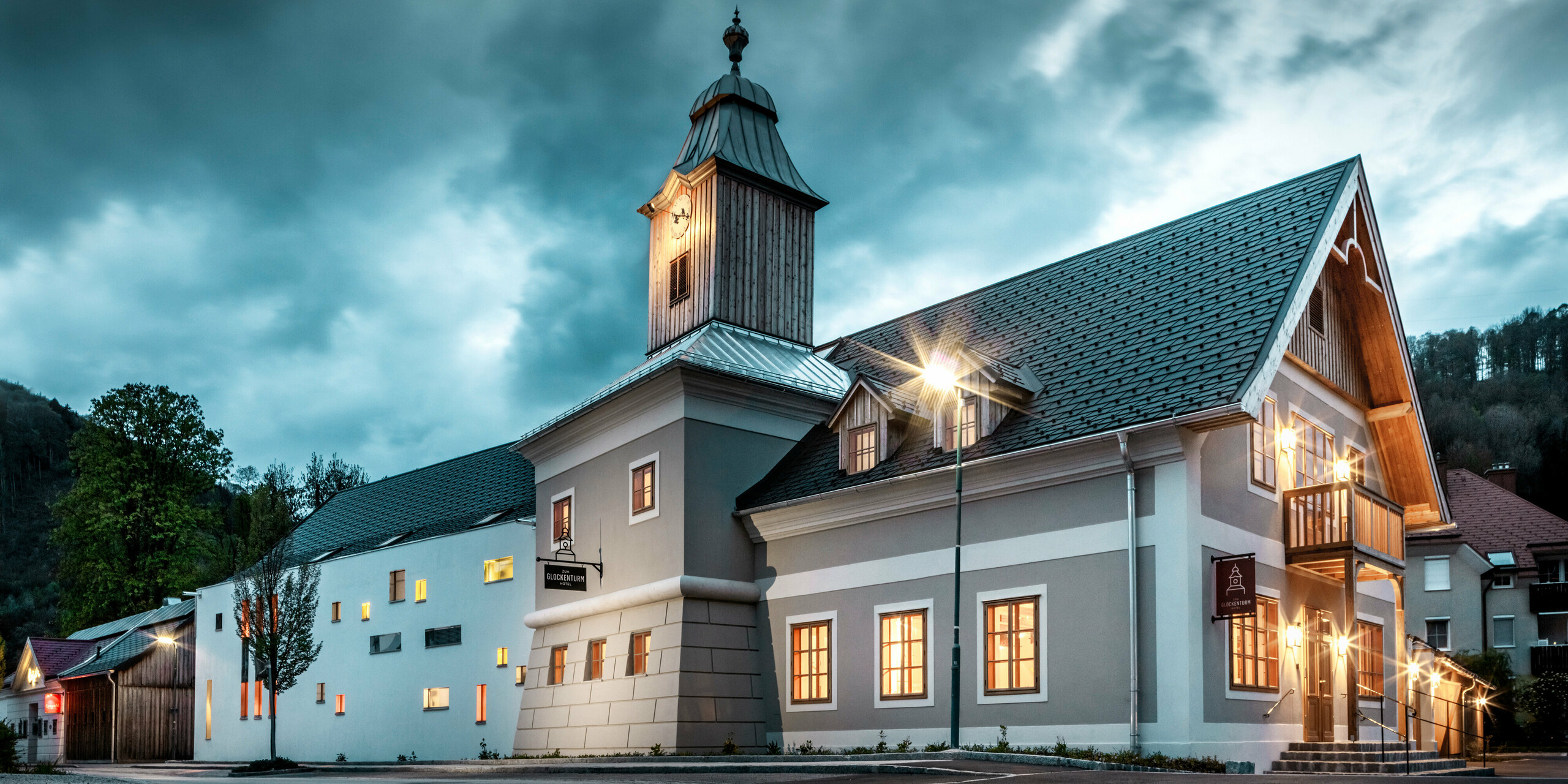 Das Dach des Hotels Glockenturm in Marktl bei Lilienfeld wurde mit der PREFA Dachschindel in P.10 Anthrazit verkleidet. Das PREFA Dachentwässerungssystem des Gebäudes ist in Naturblank gehalten. Unweit vom Hotel Glockenturm liegt das Leopold - unser Wirtshaus. Das Restaurantgebäude wurde ebenfalls mit PREFA Produkten eingedeckt.