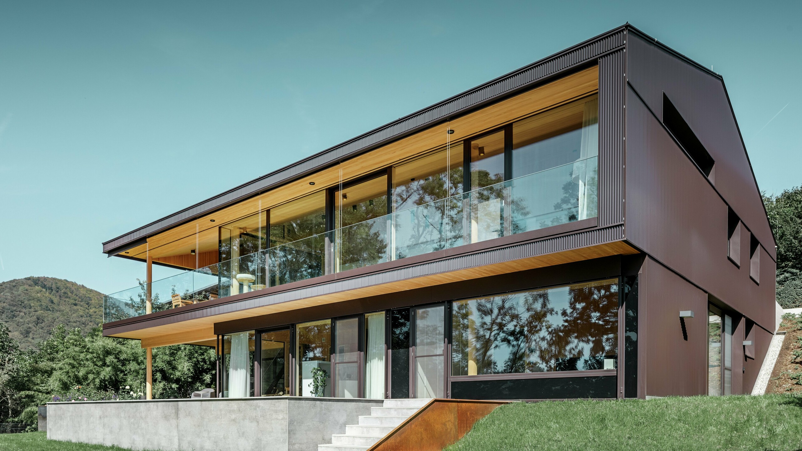 Tento moderný rodinný dom v Linzi má priestrannú terasu a veľké okná na strane záhrady. Fasáda bola obložená prelamovaným profilom PREFA Zackenprofil v orieškovohnedej farbe. Jedinečná fasáda z extrudovaného hliníka mení svoj vzhľad v závislosti od dopadu svetla a dodáva objektu jedinečný vzhľad.