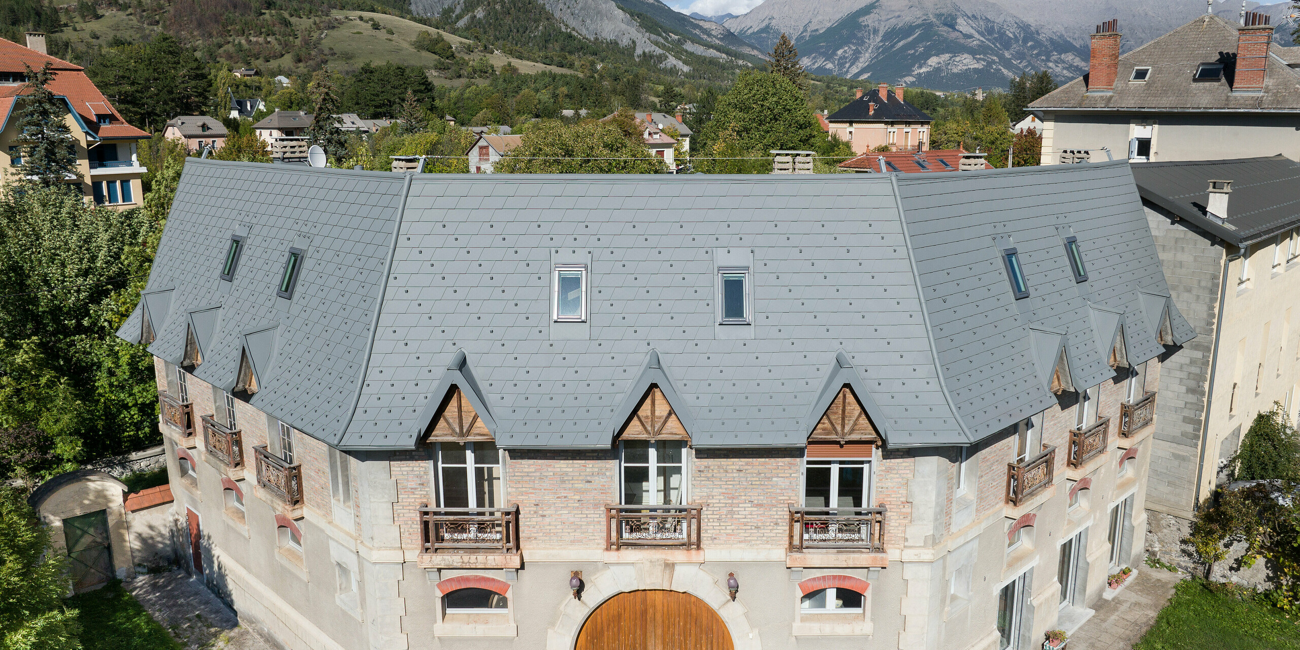 Pohľad spredu na nehnuteľnosť v Barcelonnette, Francúzsko. Extenzívna strecha bola renovovaná strešným šindľom PREFA vo farbe svetlošedá P.10.