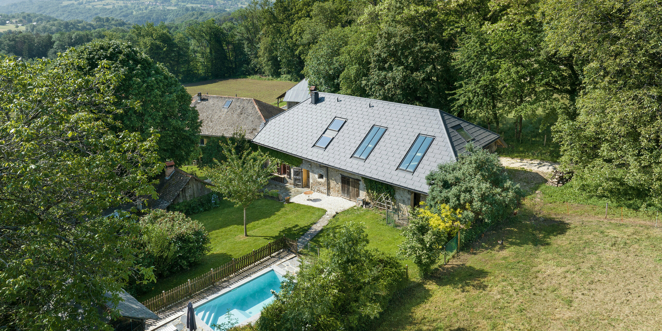 PREFA strešný panel R.16 v P.10 tmavošedej farbe na streche starej farmy v Héry-sur-Alby (Francúzsko)
