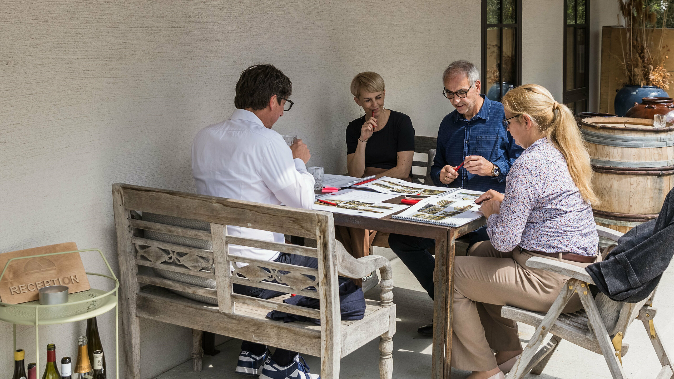 Malá pracovná skupina na odbornom dialógu PREFARENZEN 2026 vo Winzerresidenz v Seewinkel, Burgenland: Judit Nemere (generálna riaditeľka PREFA Maďarsko), Veronika Roll (marketing PREFA Rakúsko), Sven Disser (vedúci vývoja, Bauwerk) a Wolfgang Croce (Croce & Wir, Graz) diskutujú o kvalite predložených architektonických projektov. Zameriavajú sa na kreatívne využitie hliníkových riešení PREFA v súčasnej architektúre. Uvoľnená atmosféra podporuje sústredenú výmenu názorov na inovácie, funkčnosť a kontext.