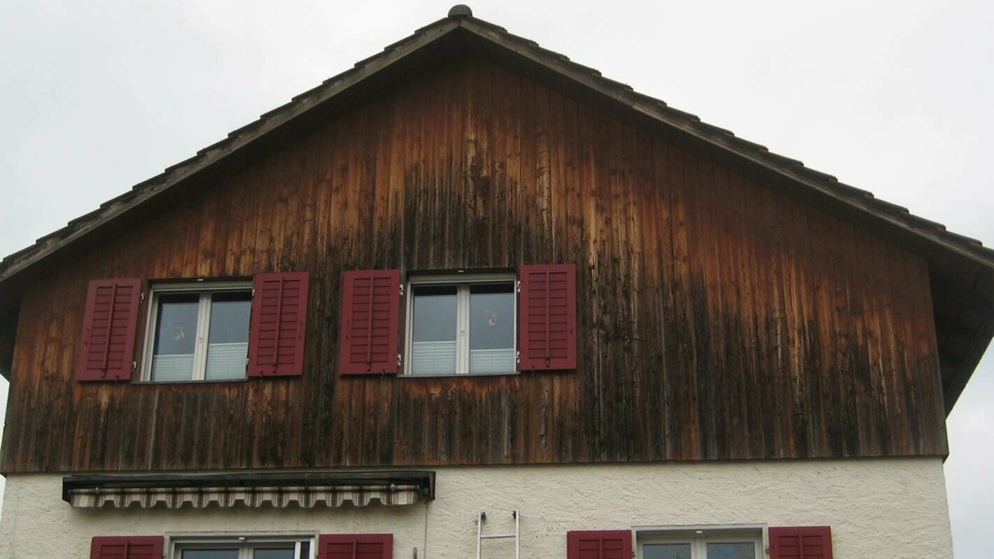 Fasáda domu so zvetraným drevom pred rekonštrukciou s použitím PREFA Sidings