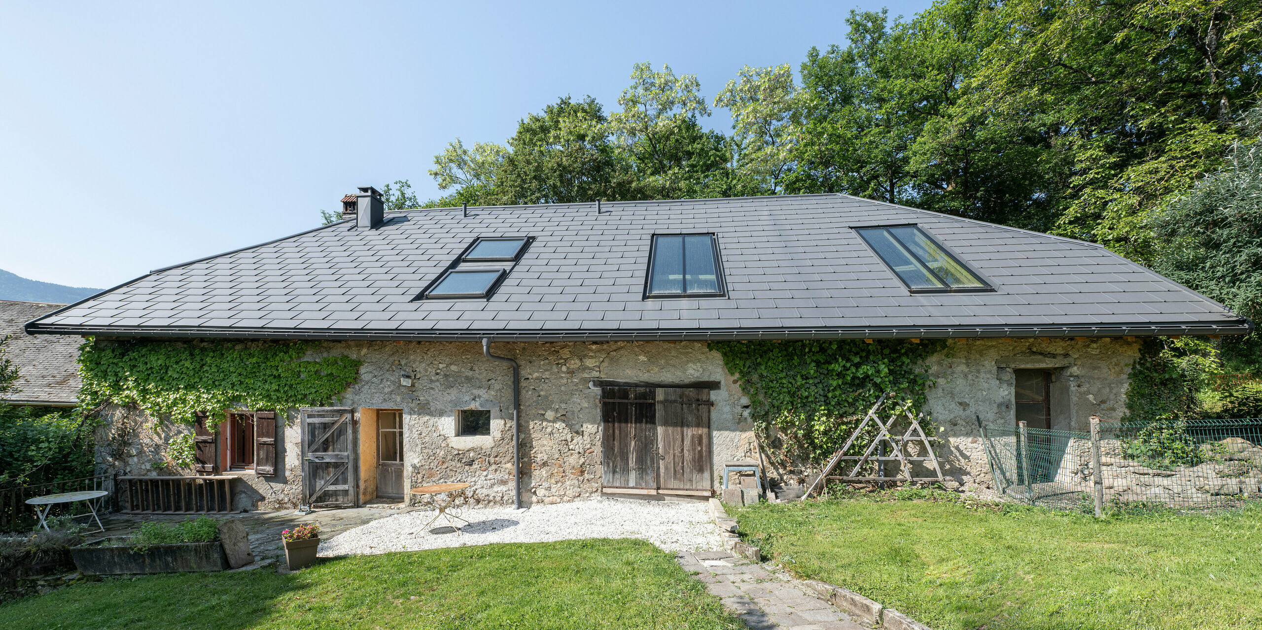 PREFA strešný panel R.16 v P.10 tmavošedej farbe na streche starej farmy v Héry-sur-Alby (Francúzsko)