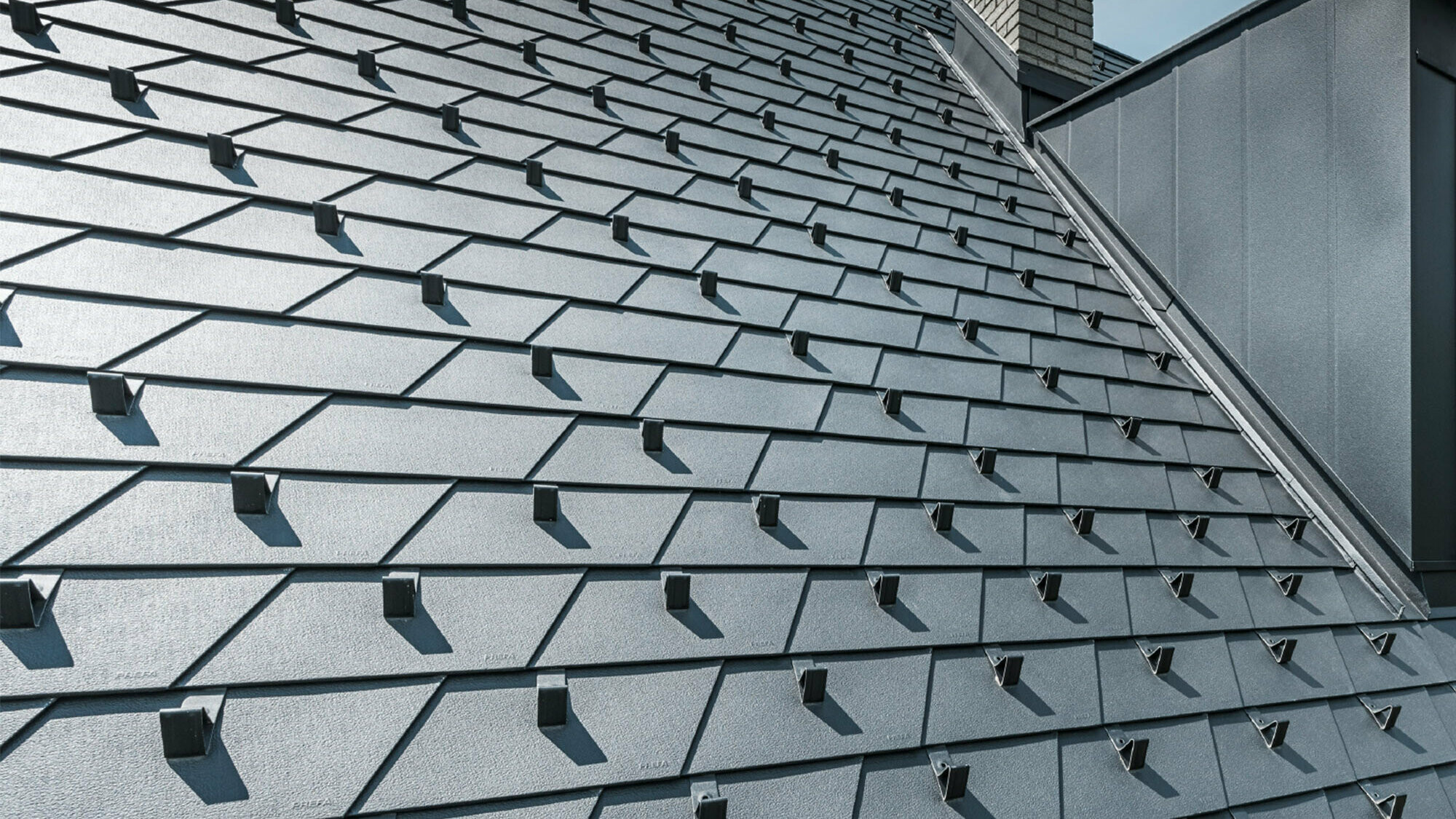 novozrekonštruovaná strecha so strešným šindľom PREFA vo farbe P.10 čierna vrát. zachytávačov snehu, vikiera obloženého hliníkom PREFA