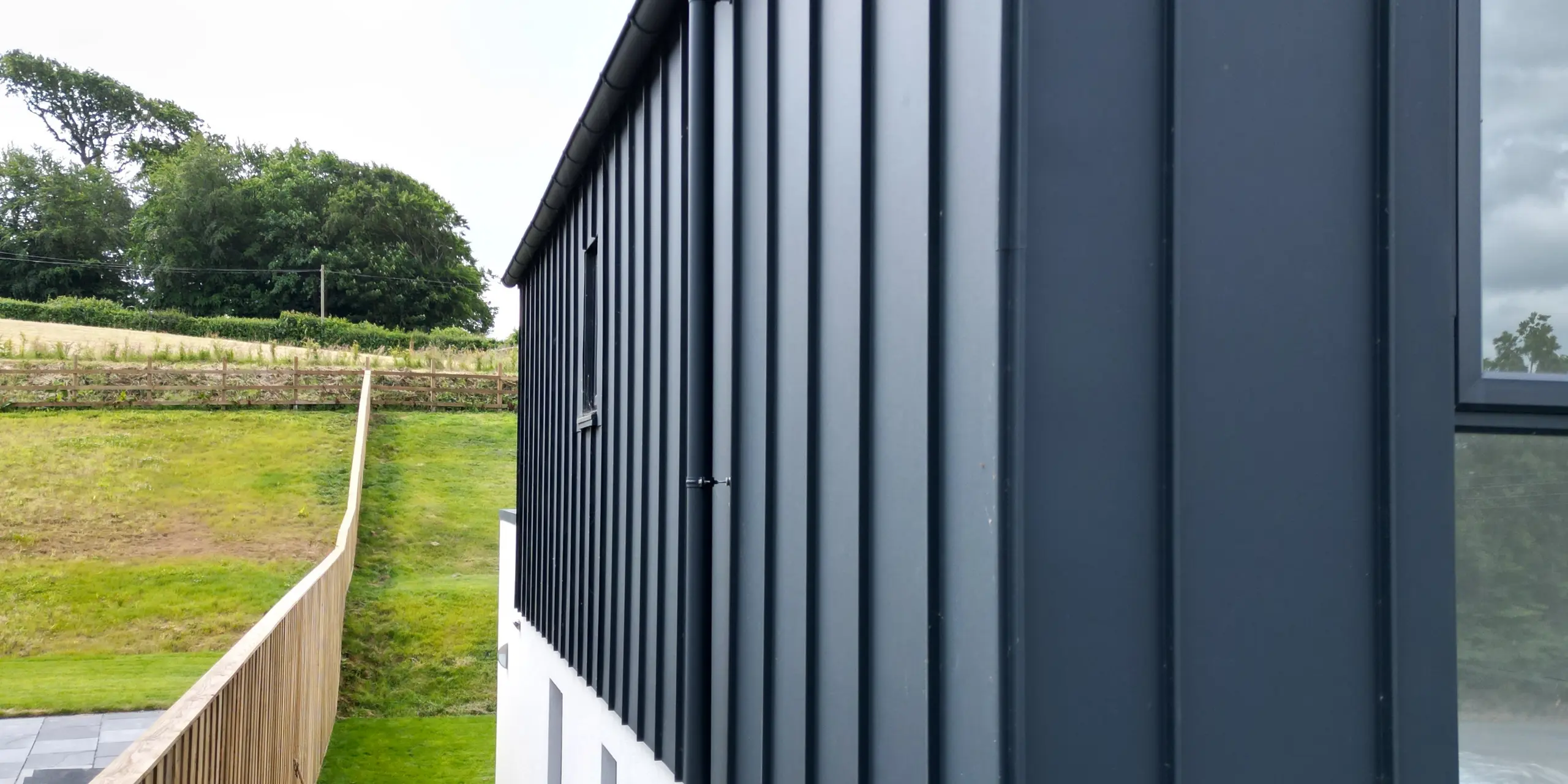 Nahaufnahme der PREFALZ Fassade in P.10 Anthrazit, die das hochwertige Aluminium und die präzise Verarbeitung der Stehfalzdeckung hervorhebt. Die klare Linienführung und die UV-beständige Oberfläche machen diese Fassade zu einem modernen Blickfang.