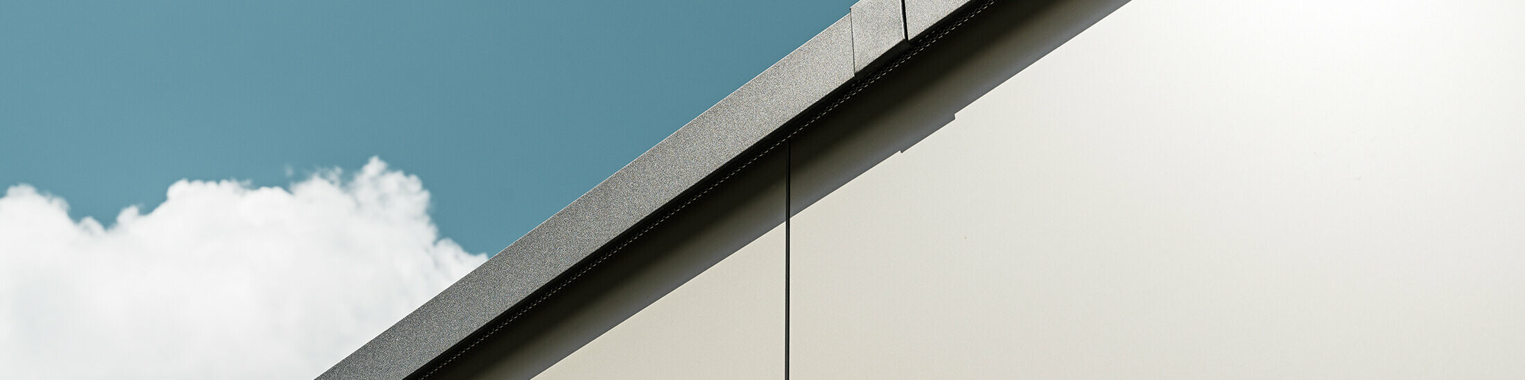 Nahaufnahme einer Garagenverkleidung mit PREFA Aluminium Verbundplatten in edlem Bronze. Die Perspektive zeigt die hohe Verarbeitungsqualität.