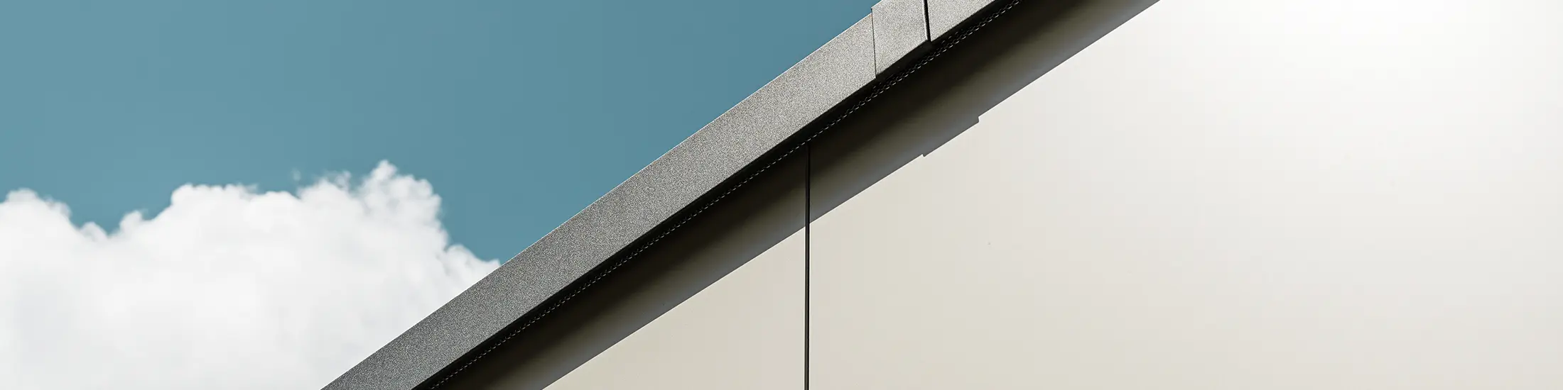 Nahaufnahme einer Garagenverkleidung mit PREFA Aluminium Verbundplatten in edlem Bronze. Die Perspektive zeigt die hohe Verarbeitungsqualität.