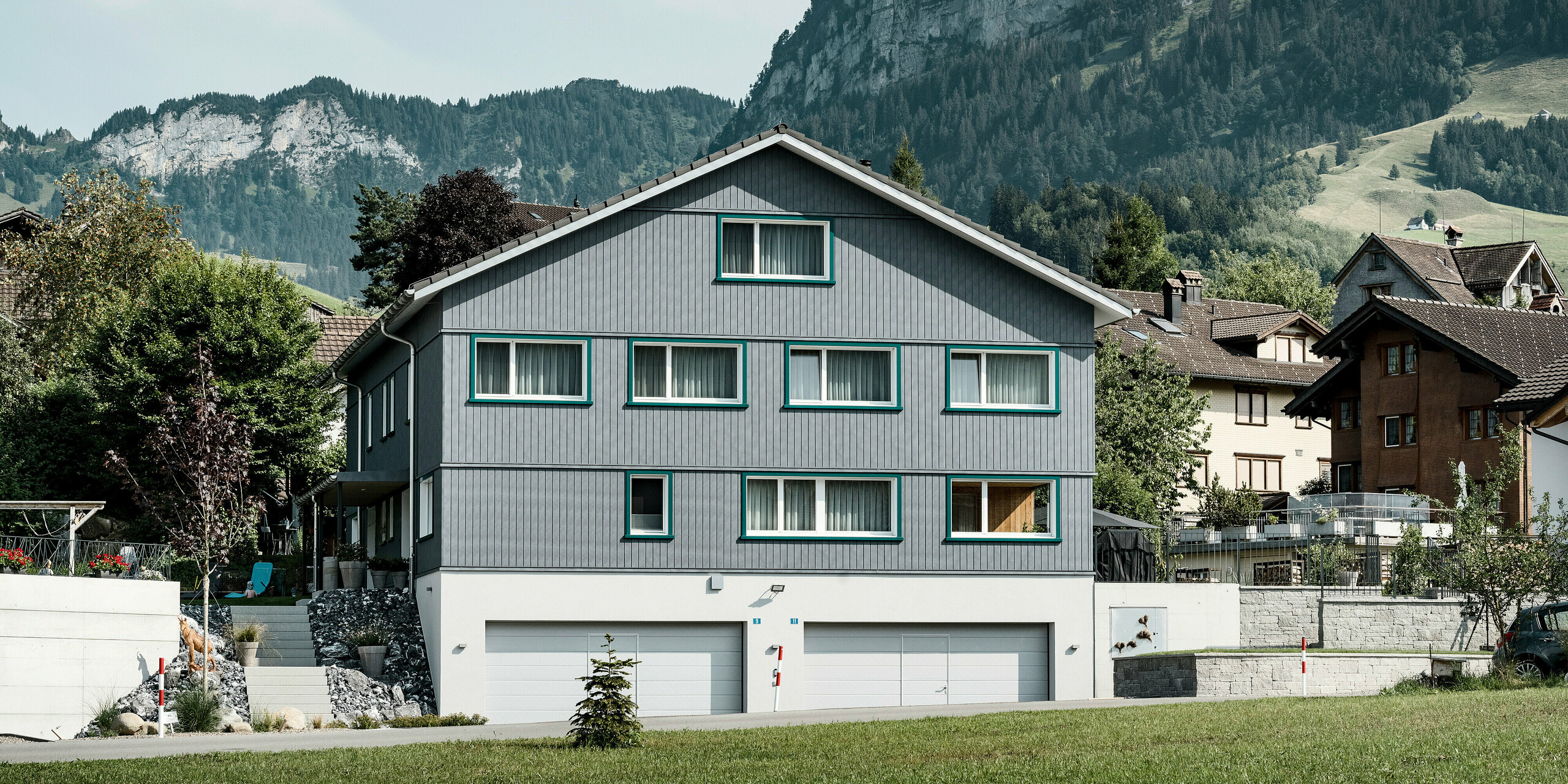 PREFA Siding vo farbe P.10 kamenná šedá a P.10 prefa biela na fasádach dvoch susedných bytových domov vo Weissbad vo Švajčiarsku.
