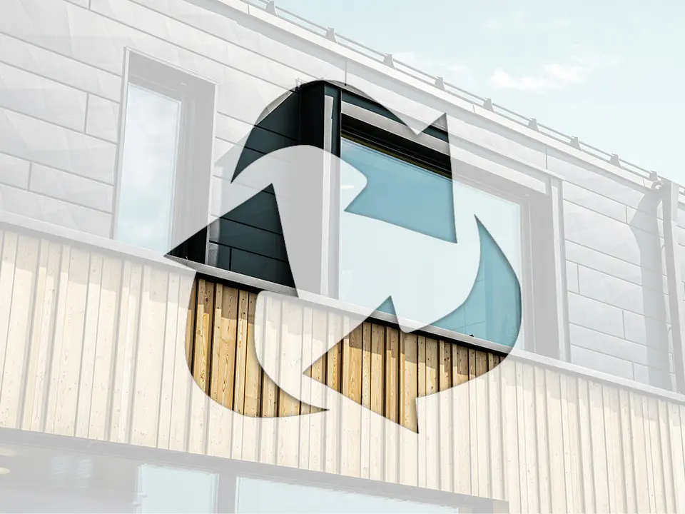 Na fotografii je symbol recyklácie pred fasádou domu s hliníkovými prvkami PREFA a drevenými panelmi.
