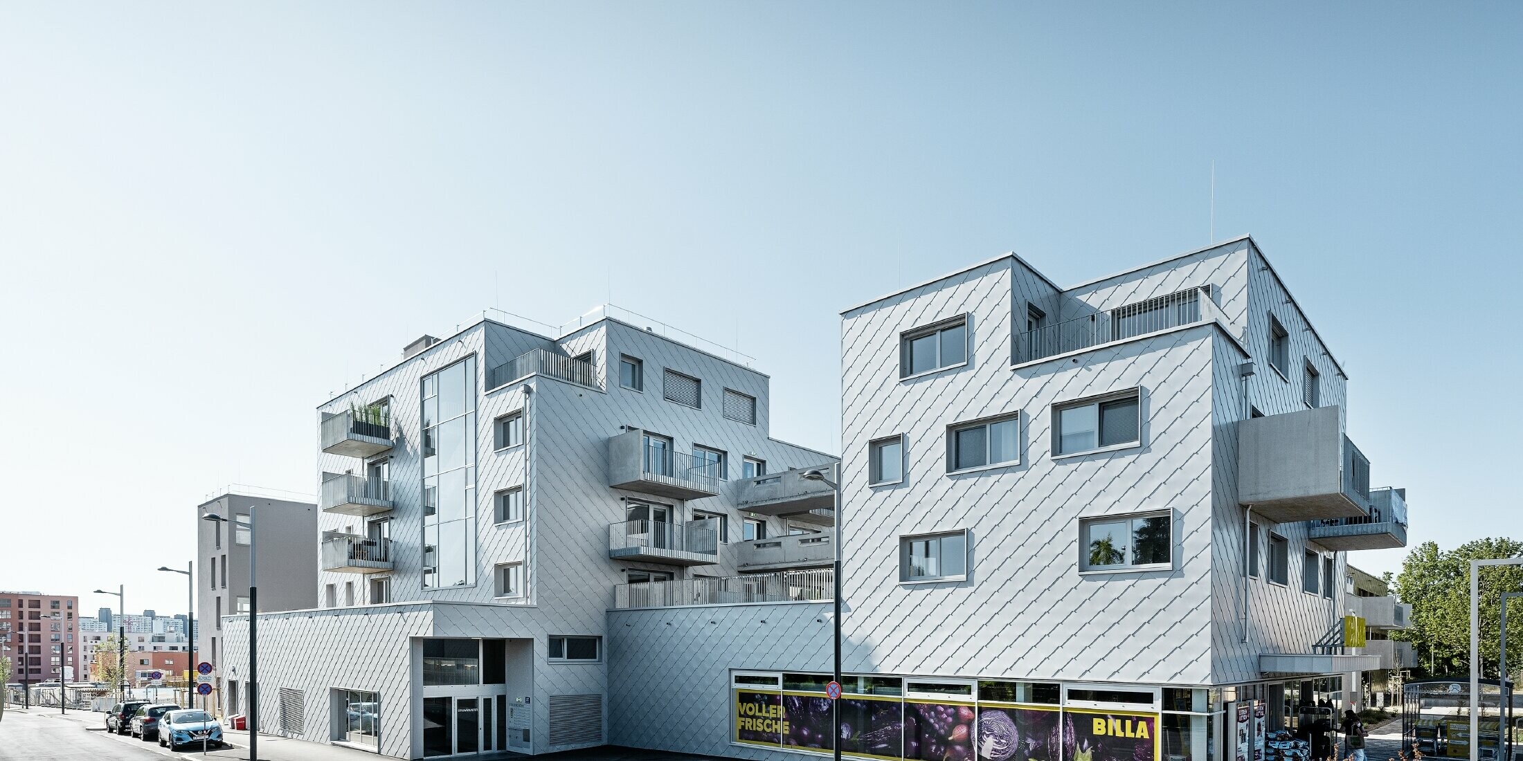 Bytové domy s plochou strechou a fasádnym obložením s PREFA fasádnou šablónou 44 × 44 vo farbe strieborná metalíza