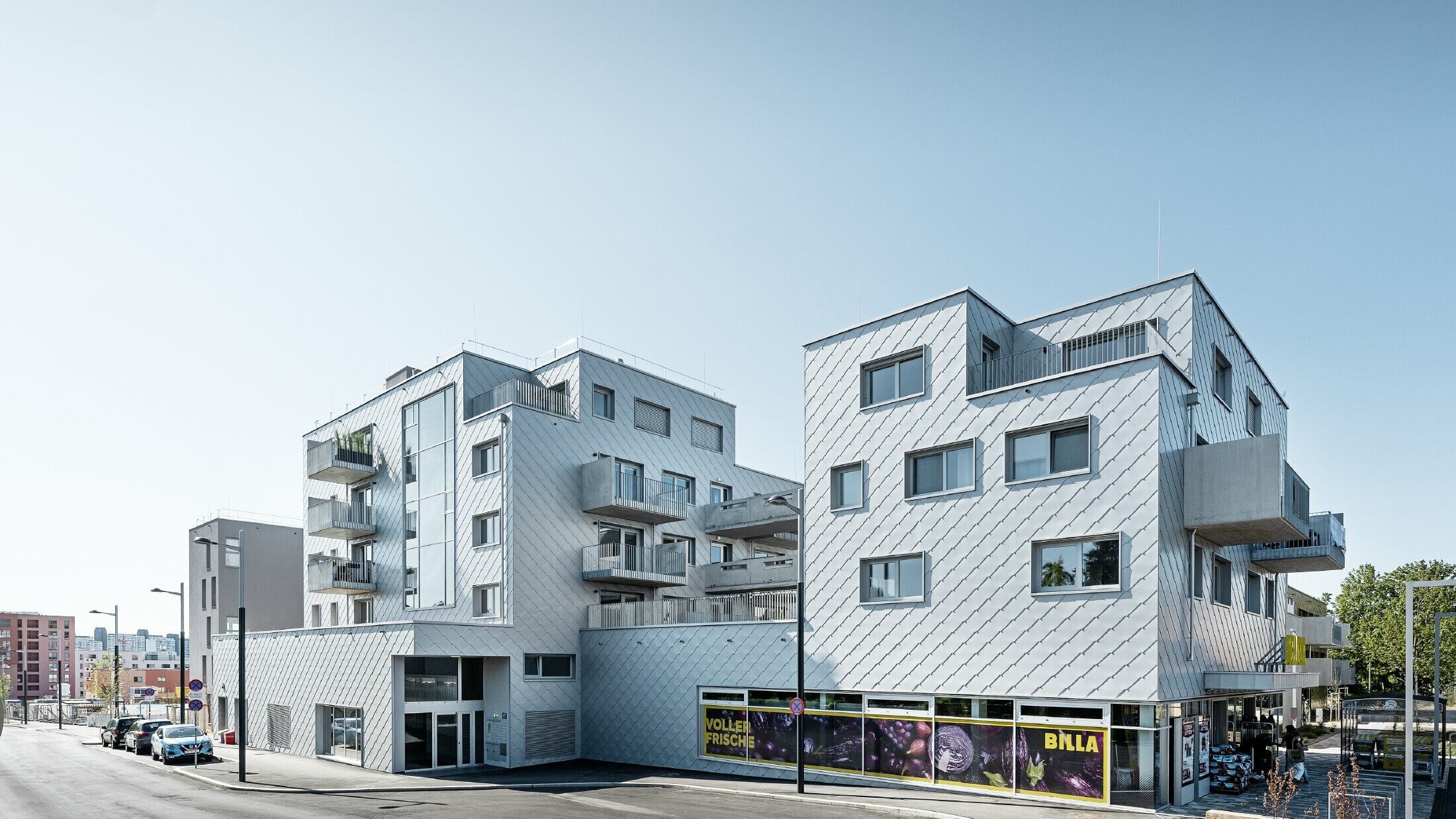 Bytové domy s plochou strechou a fasádnym obložením s PREFA fasádnou šablónou 44 × 44 vo farbe strieborná metalíza
