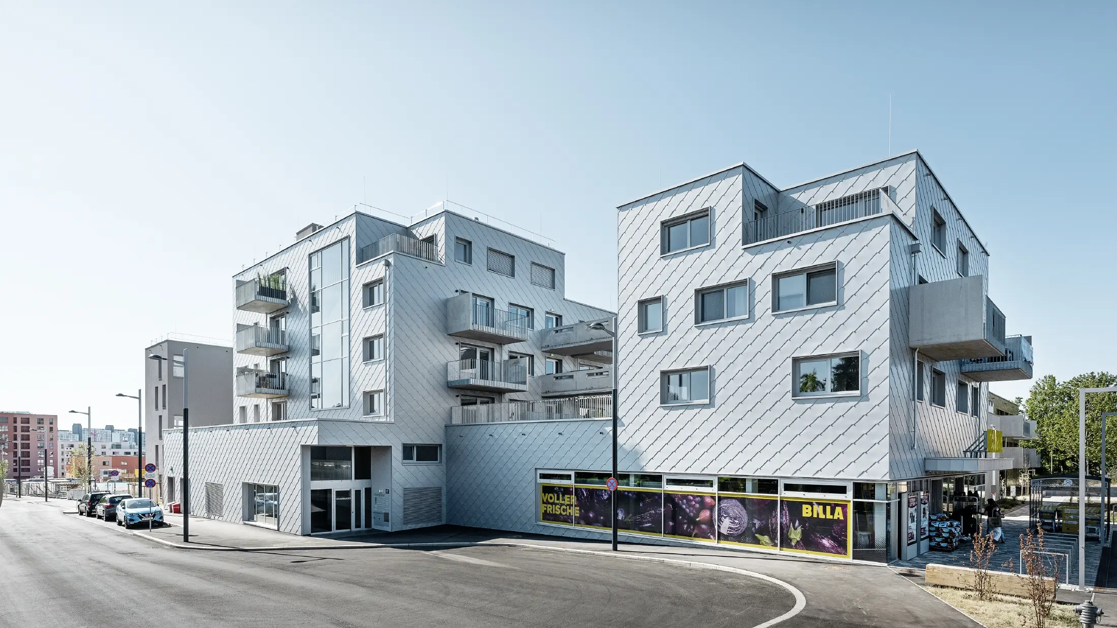 Bytové domy s plochou strechou a fasádnym obložením s PREFA fasádnou šablónou 44 × 44 vo farbe strieborná metalíza