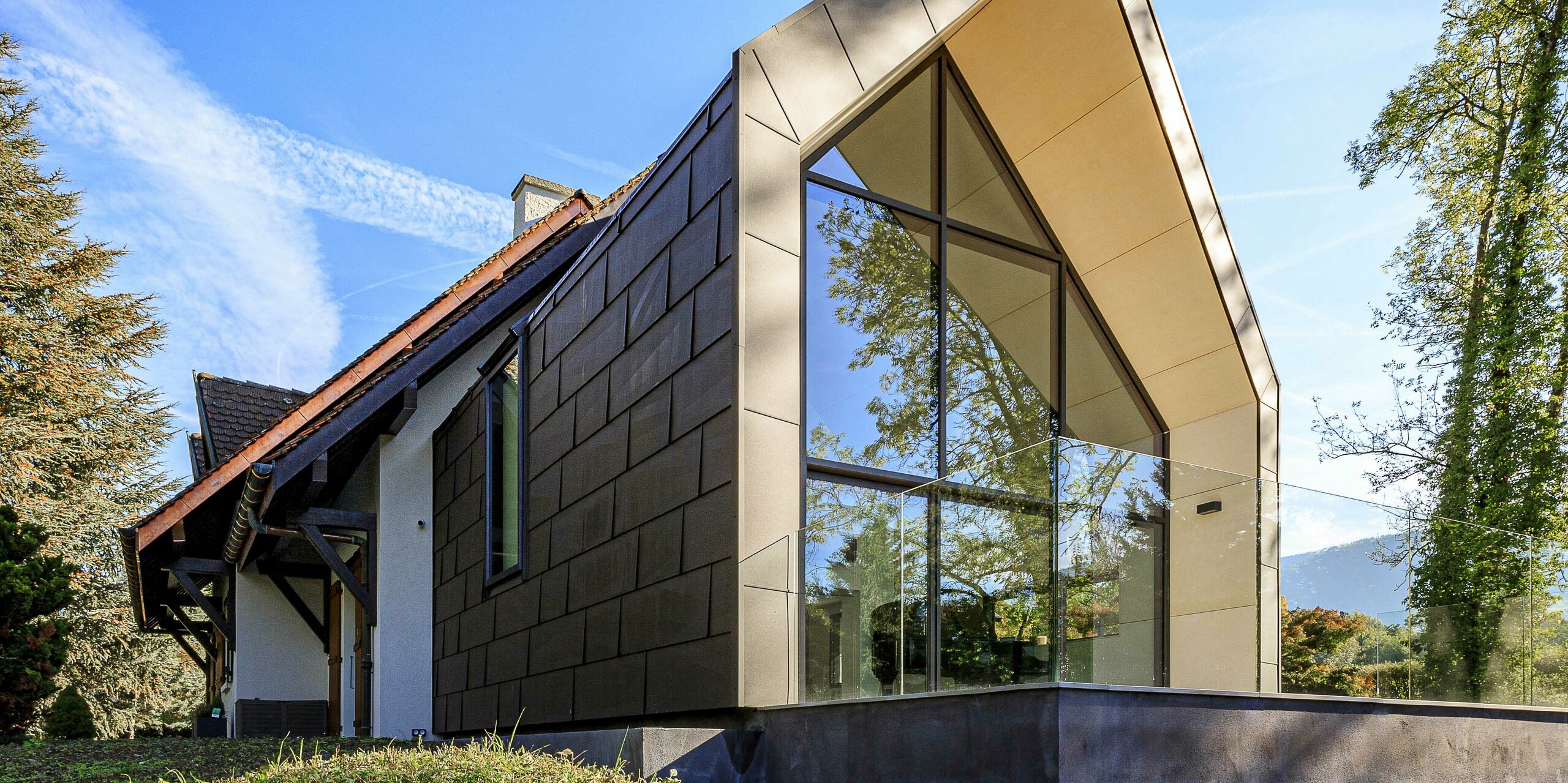 PREFA strešné a fasádne panely FX.12 v hnedej P.10 ako vysoko kontrastný dizajnový prvok na prístavbe rodinného domu v Lully