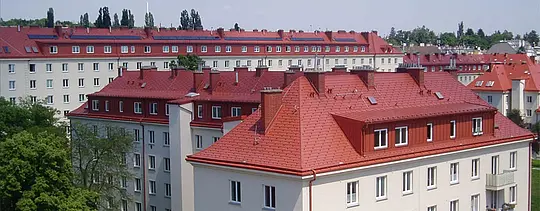 Fotografia obytných budov budovy Hugo-Breitner-Hof vo Viedni. Strechy boli pokryté šindľom PREFA v tehlovočervenej farbe.