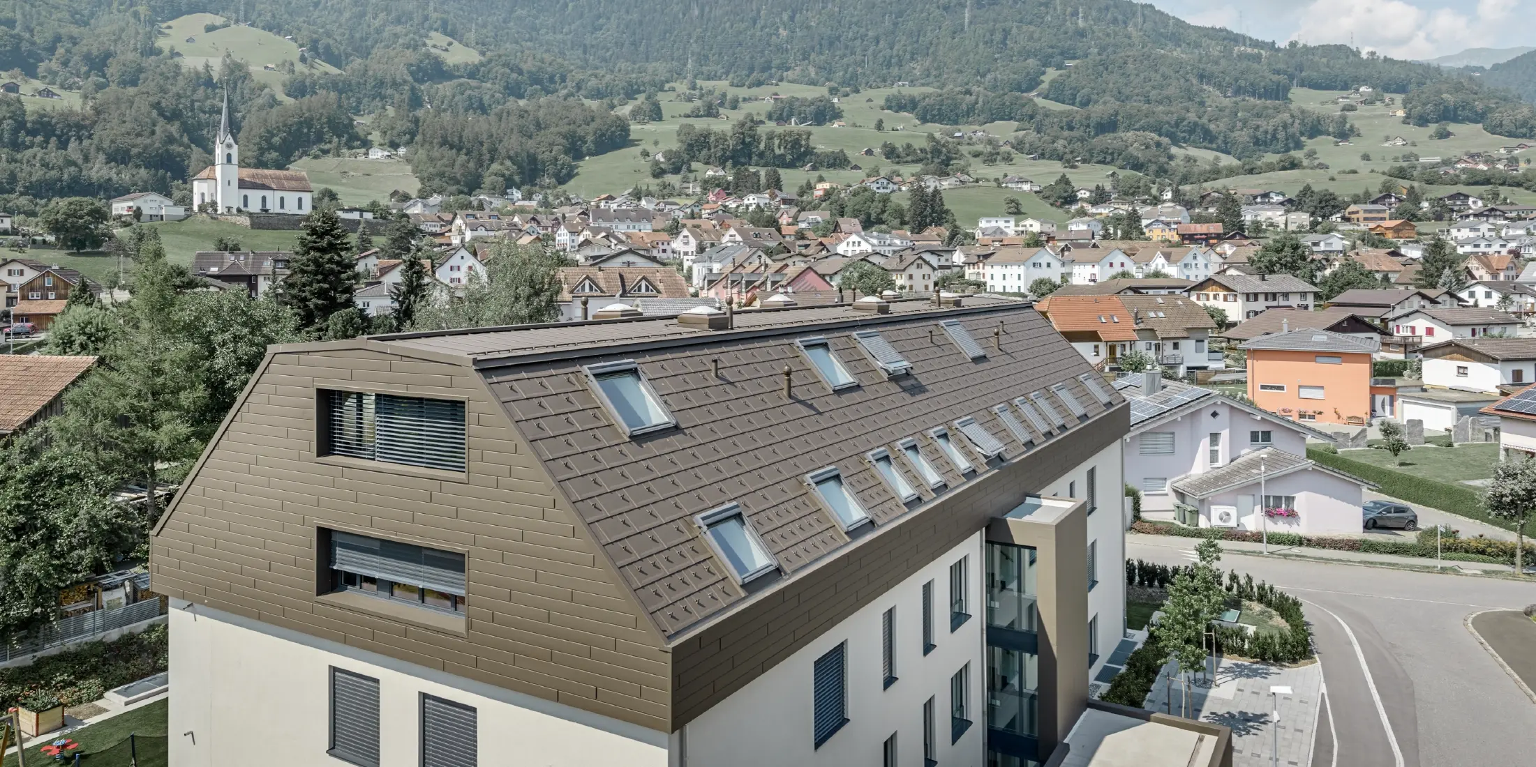 Dachgeschoßausbau des Wohnhauses in Wangs mit braunen Alu-Paneelen von PREFA für Dach und Fassade.