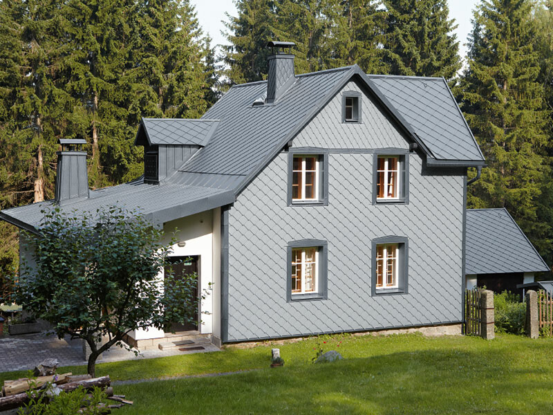 Rodinný dom s polohou v lese s PREFA hliníkovou fasádou odolnou proti poveternostným vplyvom vo farbe svetlošedá.
