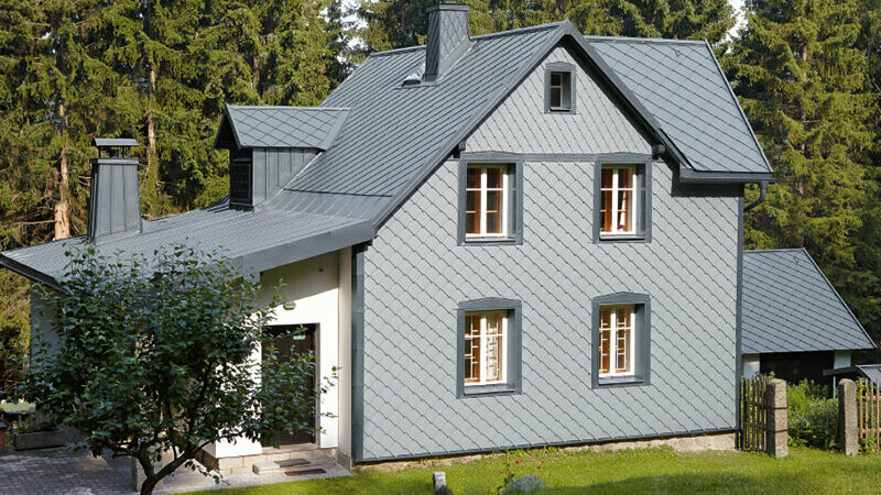 Rodinný dom s polohou v lese s PREFA hliníkovou fasádou odolnou proti poveternostným vplyvom vo farbe svetlošedá.
