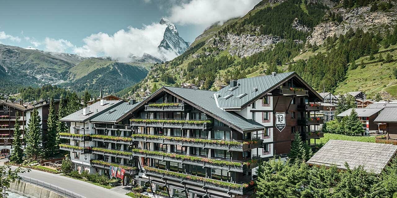 Hotel Alpenhof v Zermatte v pozadí s Matterhornom, balkóny, fasáda z tmavého dreva a hliníková strecha PREFA v antracitovej farbe