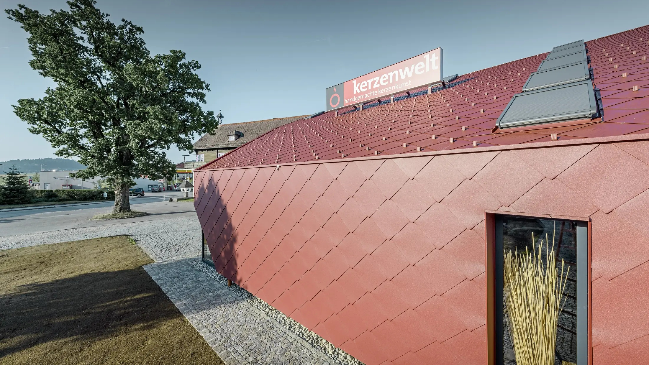 Svet sviečok v Schlägli bol úplne nanovo pokrytý šablónou PREFA. Strešná krytina a  obklad fasády boli realizované šablónou 44 × 44 vo farbe tmavočervená.