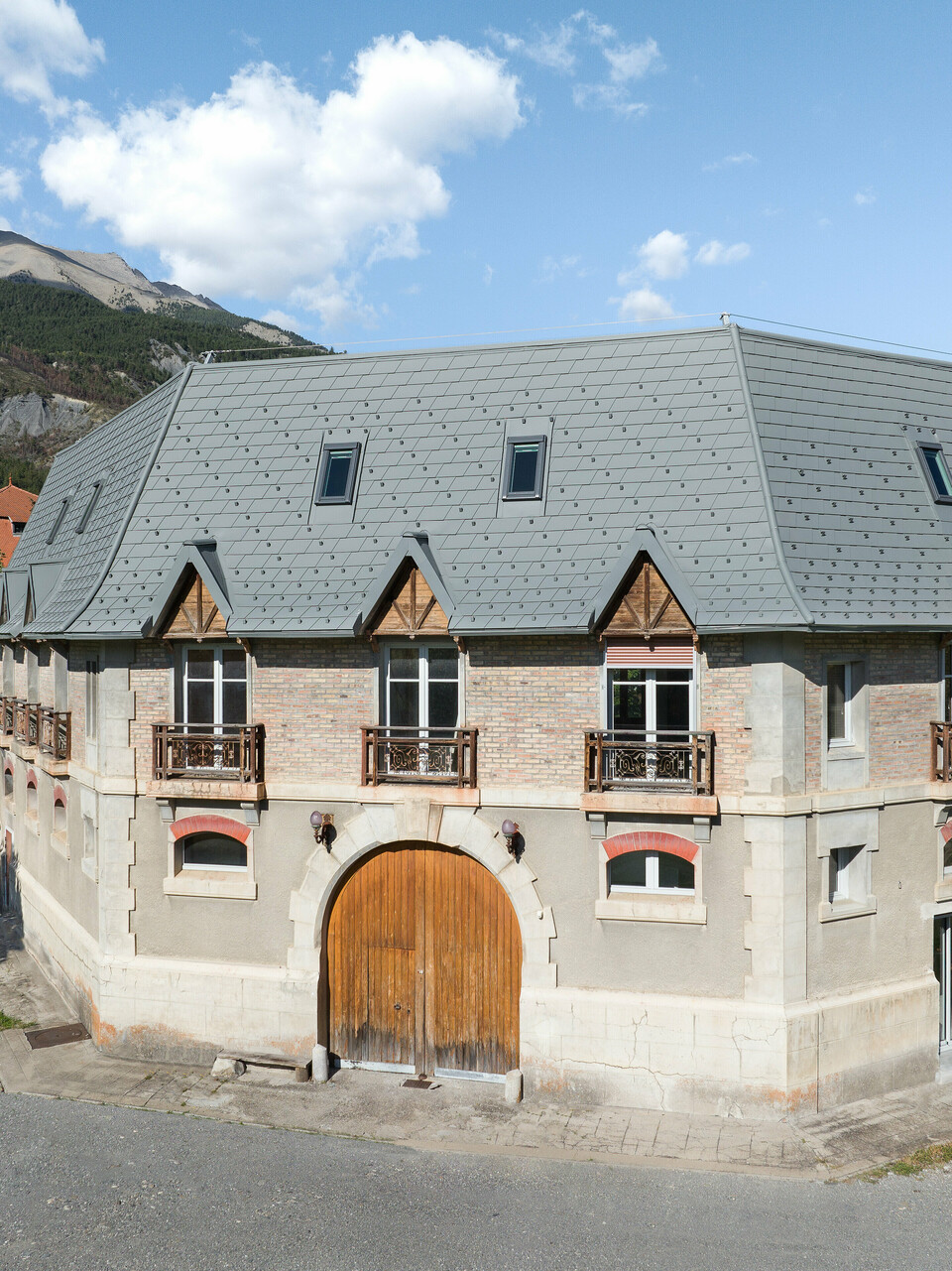Pohľad spredu na nehnuteľnosť v Barcelonnette, Francúzsko. Extenzívna strecha bola renovovaná strešným šindľom PREFA vo farbe svetlošedá P.10.