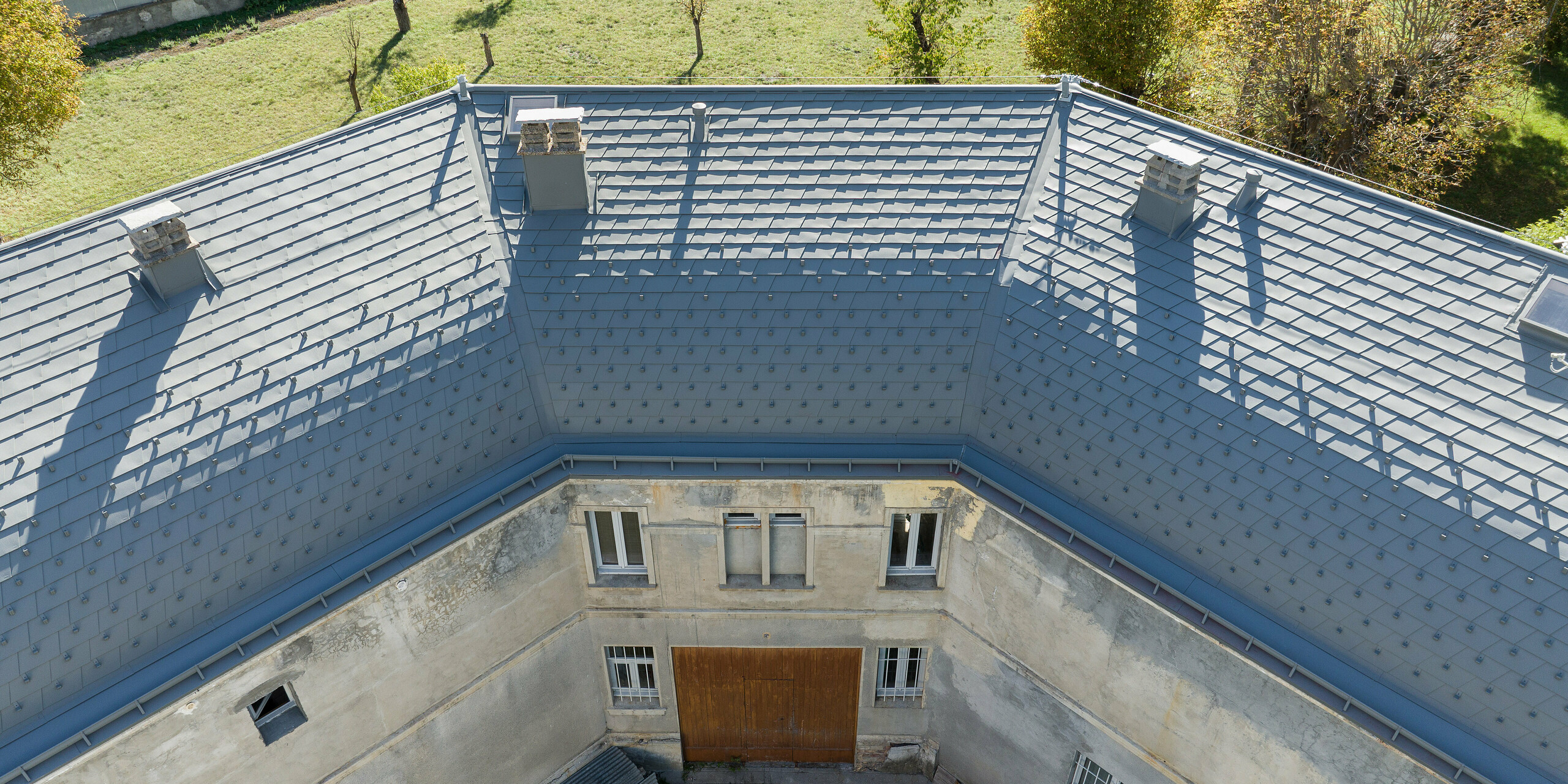 Rozsiahla strecha nehnuteľnosti v Barcelonnette vo Francúzsku bola renovovaná pomocou strešného šindľa PREFA vo farbe svetlošedá P.10.