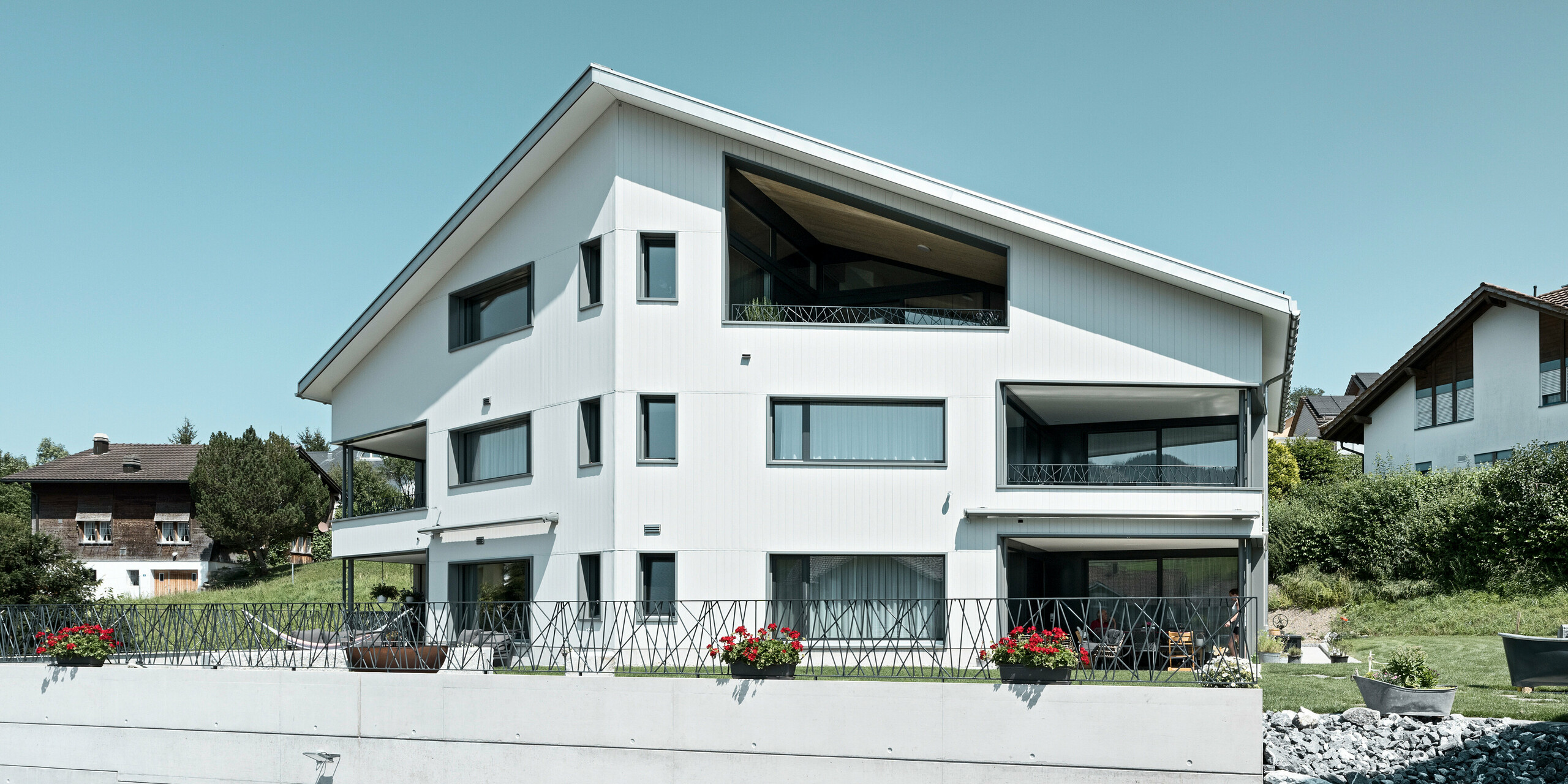 PREFA Siding vo farbe P.10 kamenná šedá a P.10 prefa biela na fasádach dvoch susedných bytových domov vo Weissbad vo Švajčiarsku.