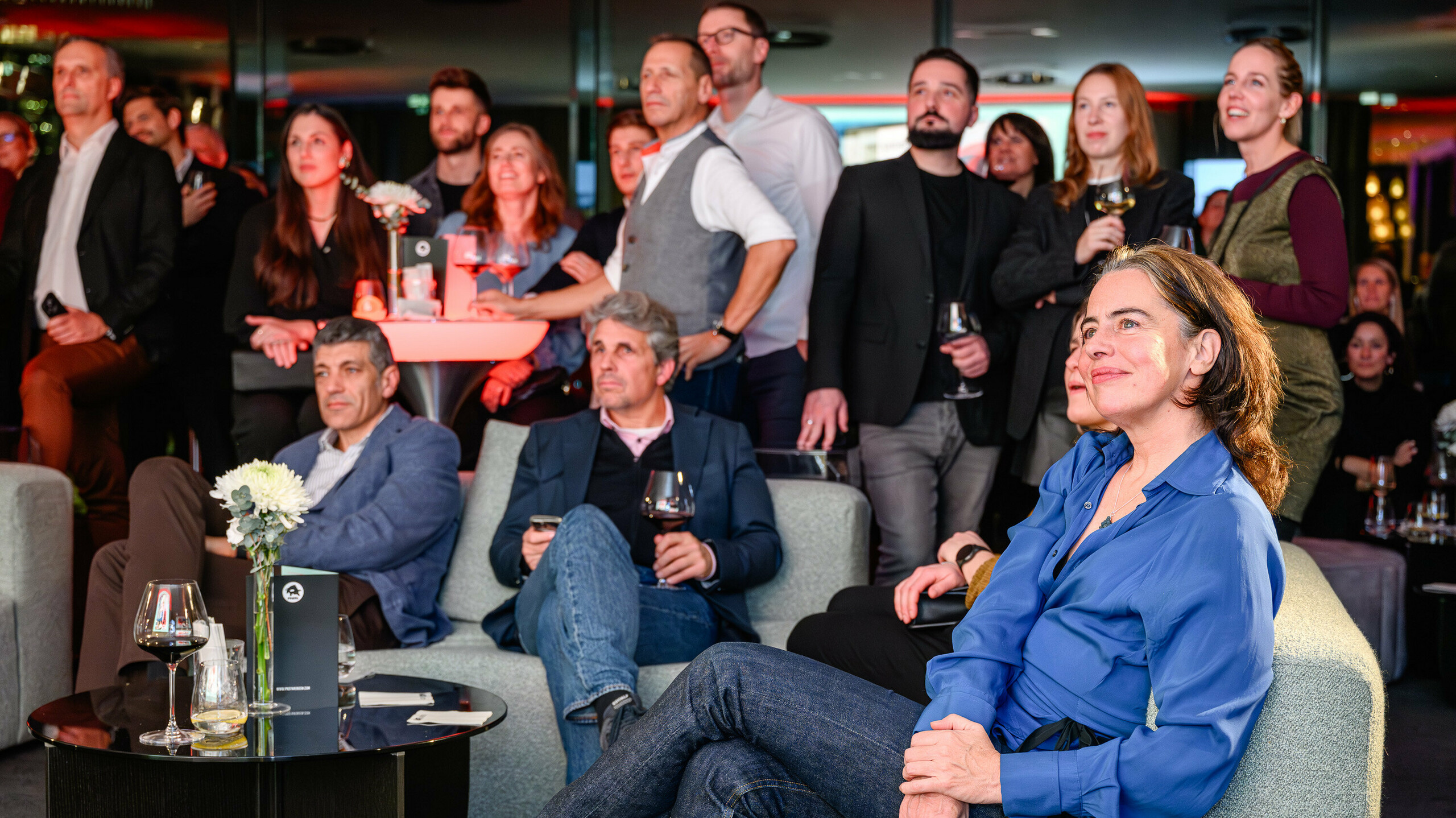 Zaujaté pohľady a inšpirované tváre na prezentácii PREFARENZEN 2026 v k47.wien: Hostia pozorne sledujú multimediálnu prezentáciu najnovších projektov PREFA. Atmosférické osvetlenie a elegantné prostredie odrážajú kvalitu prezentovaných hliníkových riešení. Scéna ukazuje: PREFA vytvára priestor pre inovácie, výmenu a kreatívne vízie. Večer, ktorý sa zameriava na silu nadčasovej architektúry a rozmanitosť moderných možností dizajnu s hliníkom.