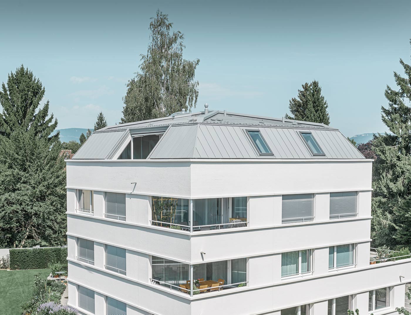 Das Wohnhaus mit weißer Putzfassade wurde mit einem Stehfalzdach von PREFA in Patina grau ausgestattet.