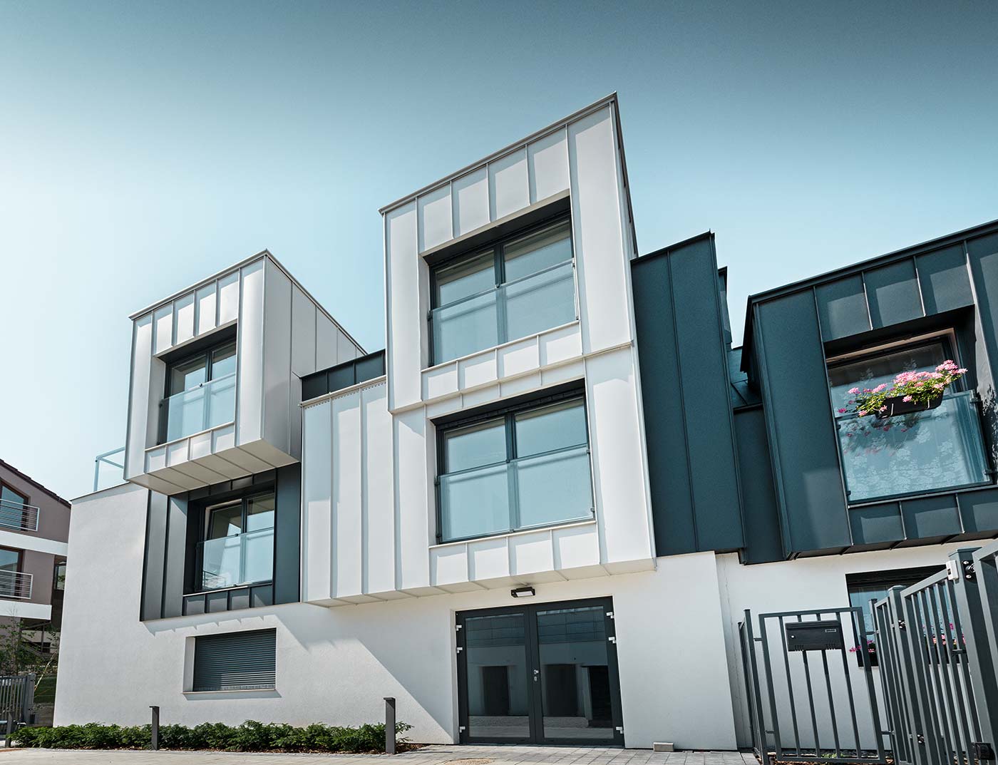 Fassadbengestaltung mit der Winkelstehfalzfassade von PREFA mit Prefalz in Reinweiß verkleidet;